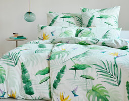 Bett mit Bio Satin Bettwäsche mit Kolibri Strelitzienblüte und grünen Tropenblättern als Design von Cotonea