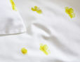 Bio-Bettwäsche Nahaufnahme der gelben Butterblumen auf weißem Satin